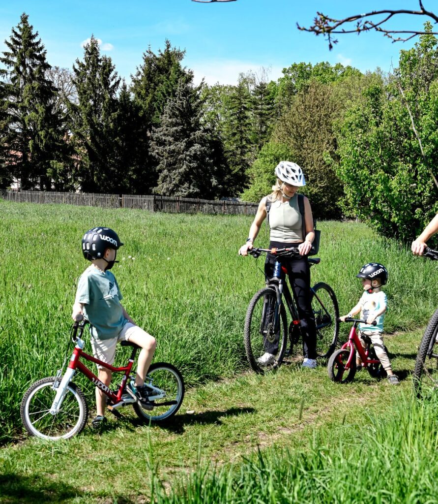 Familie mit Kindern auf Fahrrädern im Grünen
